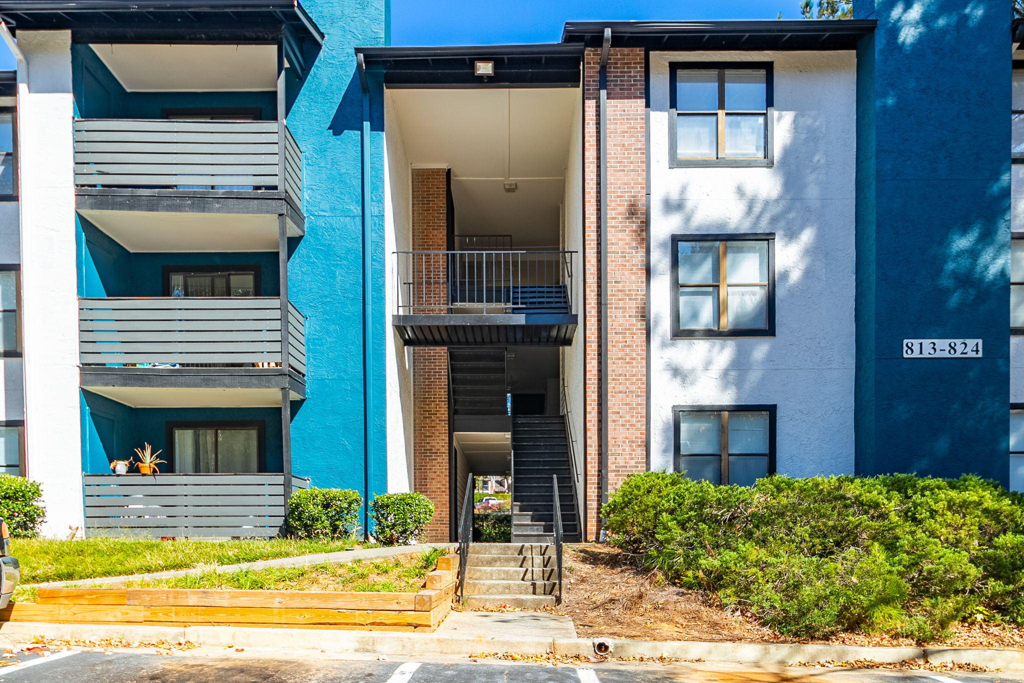 the exterior of an apartment building with blue and white trim at The  Rowen